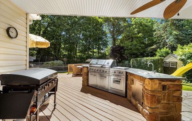 deck with area for grilling, ceiling fan, and sink