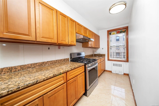 kitchen with backsplash, radiator, gas range, sink, and dark stone countertops