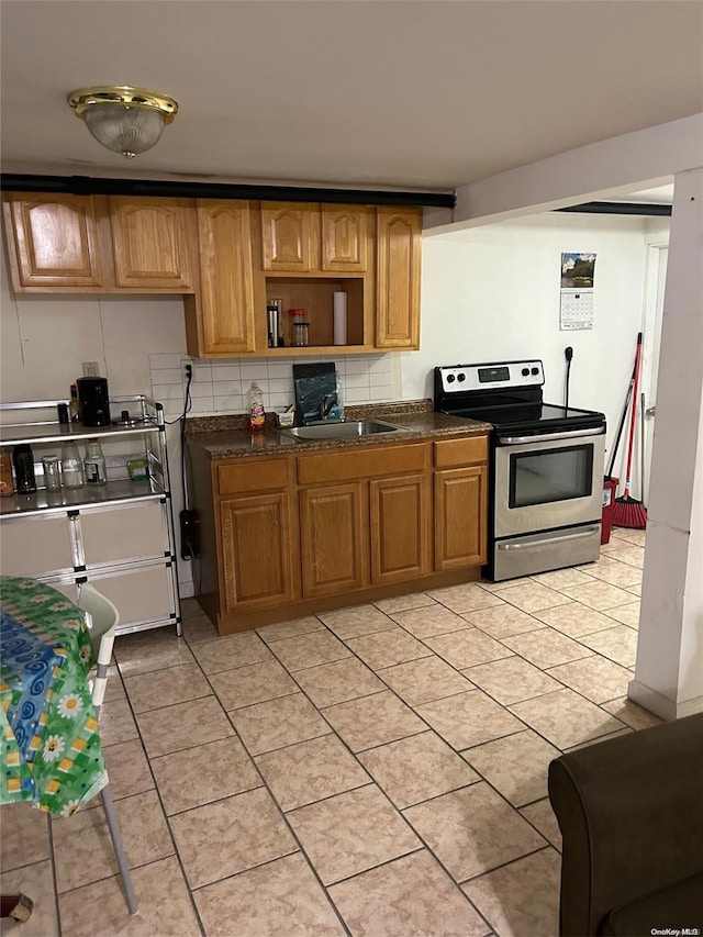 kitchen with backsplash, light tile patterned flooring, electric stove, and sink