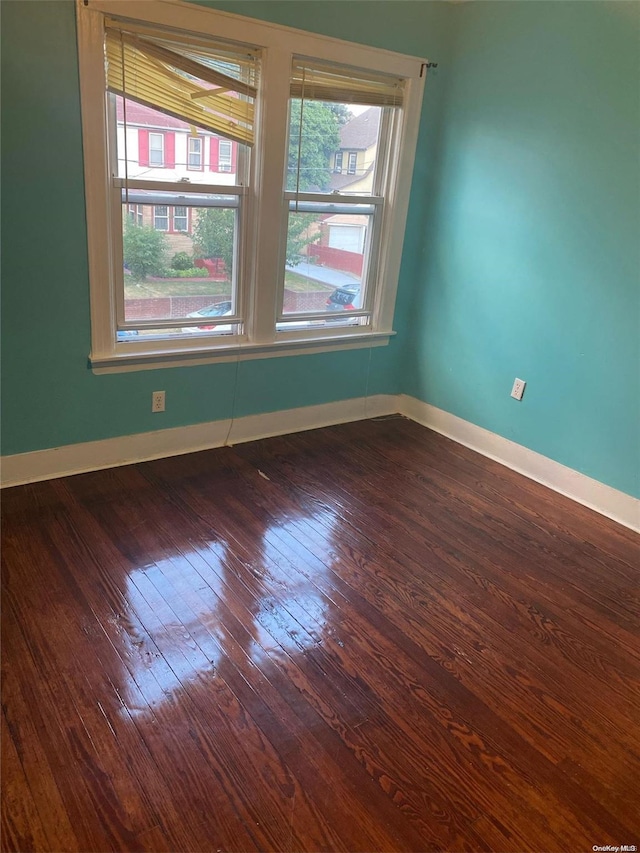 empty room with dark hardwood / wood-style flooring