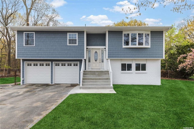 split foyer home featuring a garage and a front yard