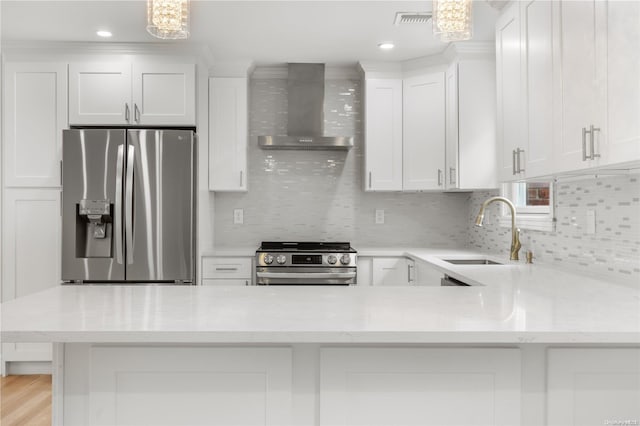 kitchen with white cabinetry, sink, stainless steel appliances, wall chimney range hood, and pendant lighting