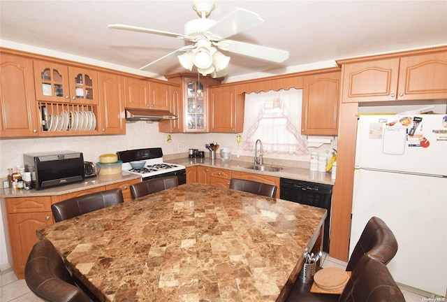 kitchen featuring a kitchen bar, ceiling fan, sink, black appliances, and a kitchen island