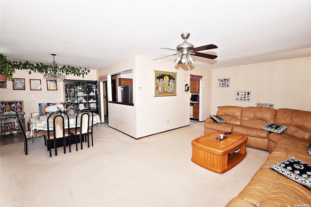 living room featuring light colored carpet and ceiling fan with notable chandelier