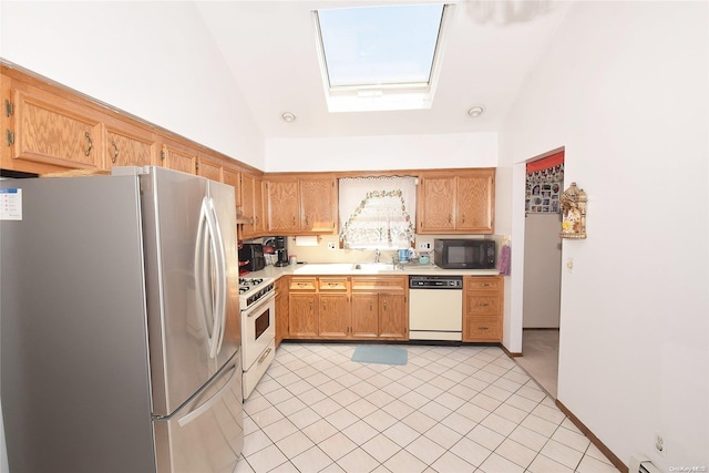 kitchen featuring sink, a baseboard heating unit, lofted ceiling with skylight, white appliances, and light tile patterned floors