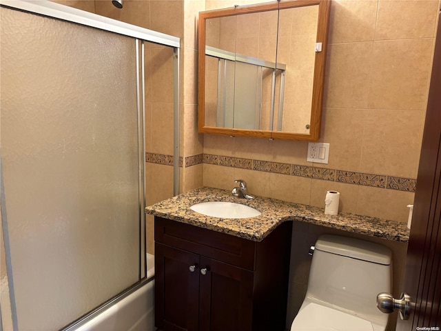 full bathroom with vanity, decorative backsplash, toilet, enclosed tub / shower combo, and tile walls