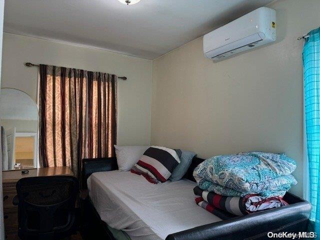 bedroom featuring a wall unit AC