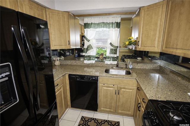 kitchen with light tile patterned floors, sink, light stone counters, and black appliances