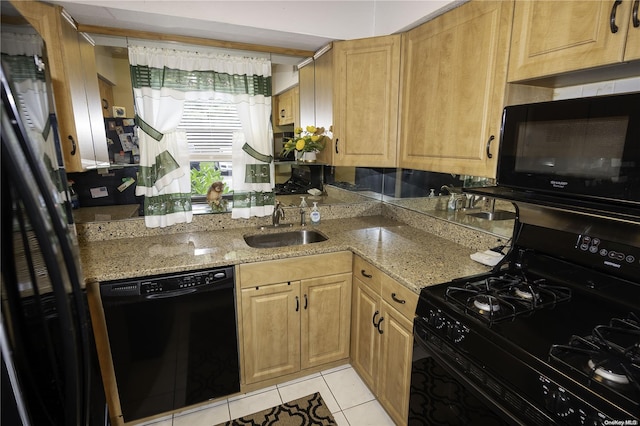 kitchen with light tile patterned floors, sink, light stone counters, and black appliances