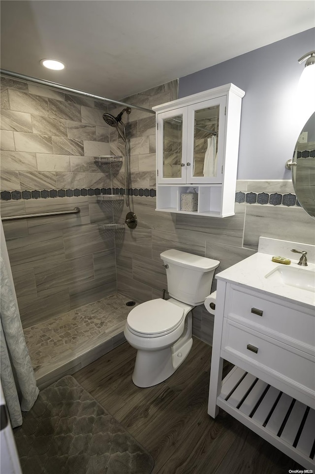 bathroom featuring vanity, toilet, tile walls, walk in shower, and wood-type flooring