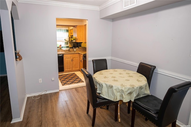 dining area with hardwood / wood-style flooring and ornamental molding