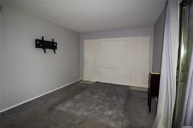 unfurnished room featuring dark carpet