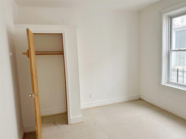 unfurnished bedroom with multiple windows and a closet