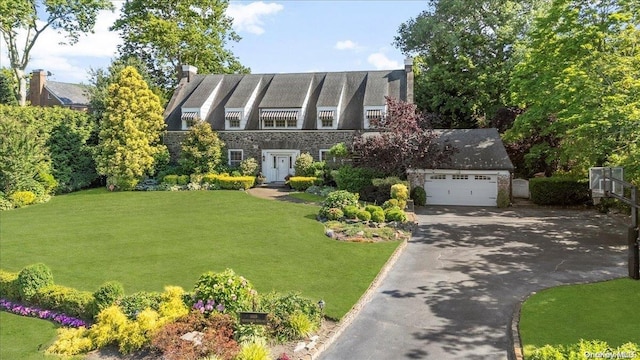 tudor-style house featuring a front lawn