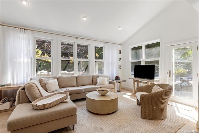 living room featuring high vaulted ceiling and a wealth of natural light