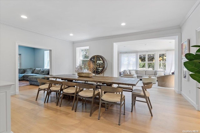 dining area with ornamental molding, a healthy amount of sunlight, and light wood-type flooring