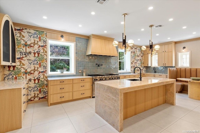 kitchen featuring a wealth of natural light, high end stainless steel range, and custom range hood