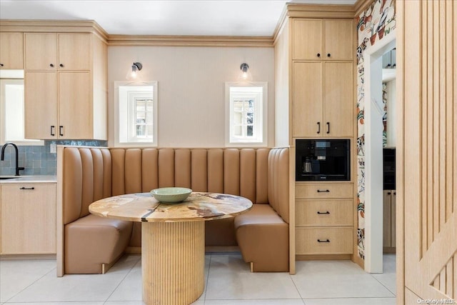 dining space with sink, breakfast area, ornamental molding, and light tile patterned flooring