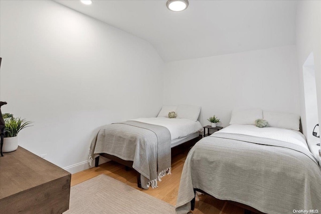 bedroom featuring hardwood / wood-style floors and vaulted ceiling