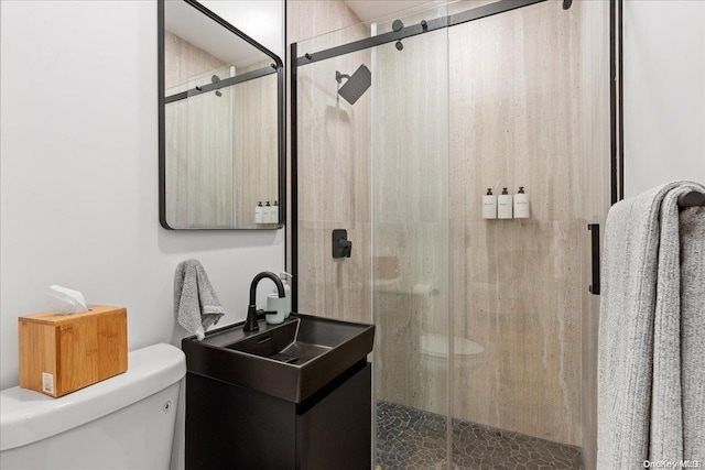 bathroom featuring an enclosed shower, vanity, and toilet