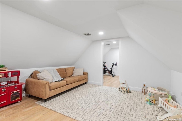 additional living space with hardwood / wood-style flooring and vaulted ceiling