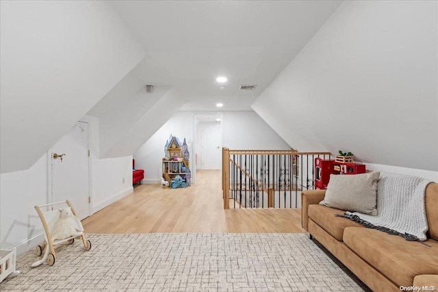 additional living space featuring lofted ceiling and light wood-type flooring