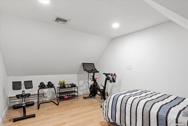 bedroom featuring light hardwood / wood-style floors and lofted ceiling