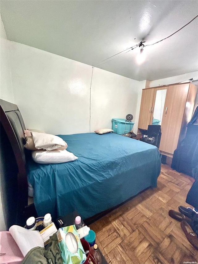 bedroom with dark parquet flooring