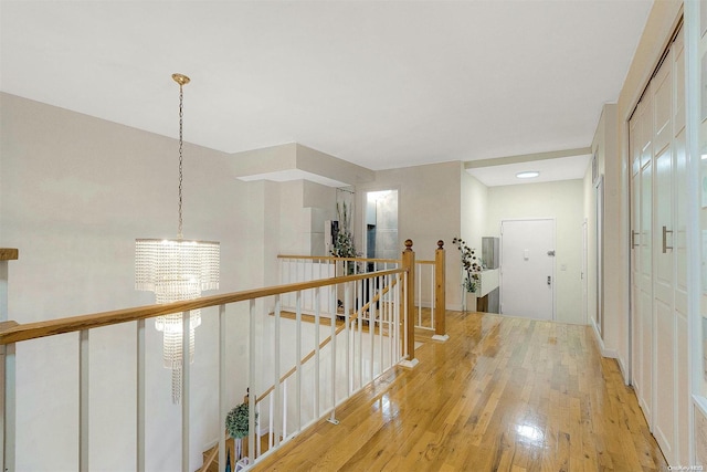 corridor featuring a chandelier and light hardwood / wood-style flooring