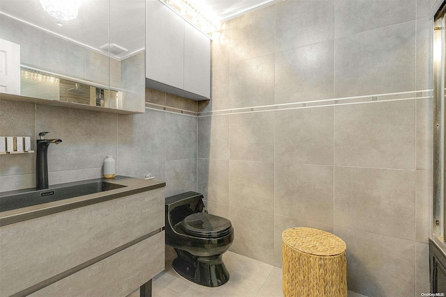 bathroom featuring tile patterned flooring, vanity, toilet, and tile walls