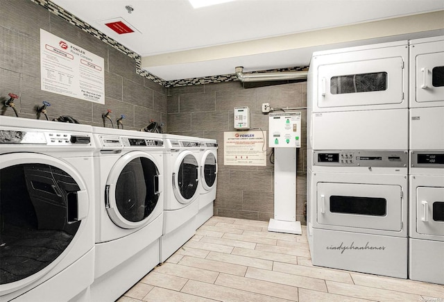 clothes washing area featuring washing machine and dryer, stacked washer and dryer, and tile walls