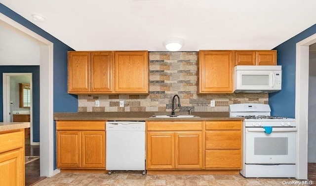 kitchen featuring backsplash, white appliances, and sink