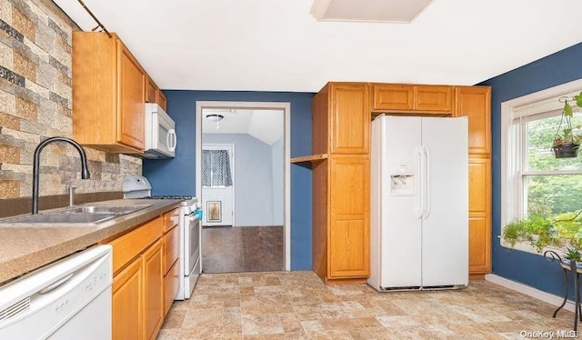 kitchen featuring white appliances, sink, and tasteful backsplash