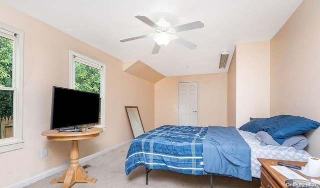 bedroom with multiple windows, ceiling fan, and carpet