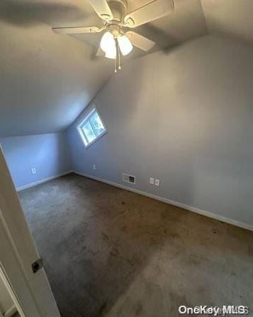 bonus room featuring dark carpet, vaulted ceiling, and ceiling fan