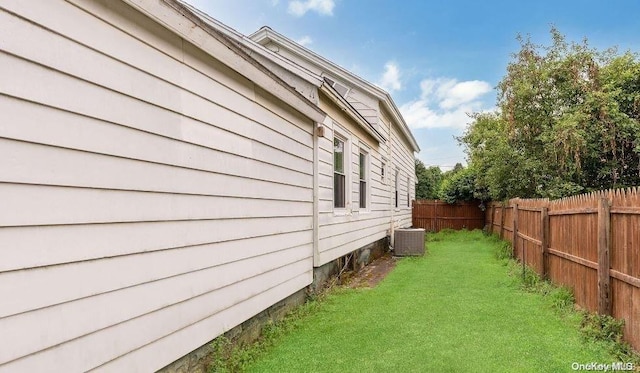 view of home's exterior with a lawn and central AC unit