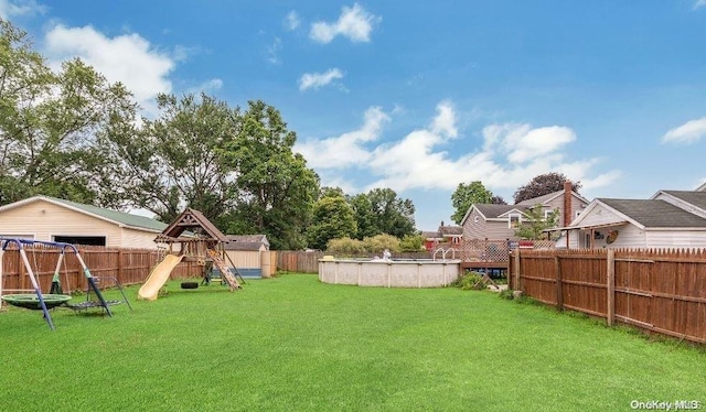 view of yard featuring a playground and a fenced in pool