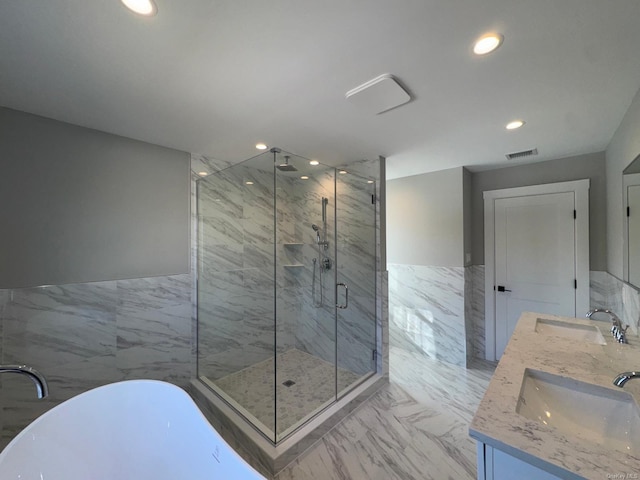 bathroom with plus walk in shower, vanity, and tile walls