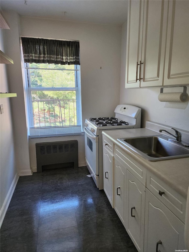 kitchen with white gas range oven, sink, and radiator