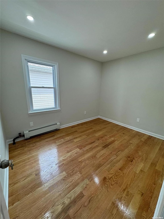 spare room featuring light hardwood / wood-style flooring and a baseboard heating unit