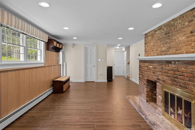 unfurnished living room featuring a fireplace, dark hardwood / wood-style flooring, a baseboard radiator, and ornamental molding