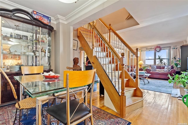 dining area with hardwood / wood-style flooring and crown molding