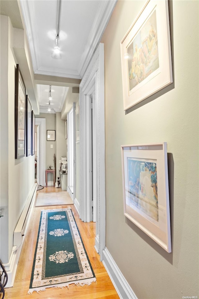 hall with crown molding, rail lighting, and light hardwood / wood-style floors