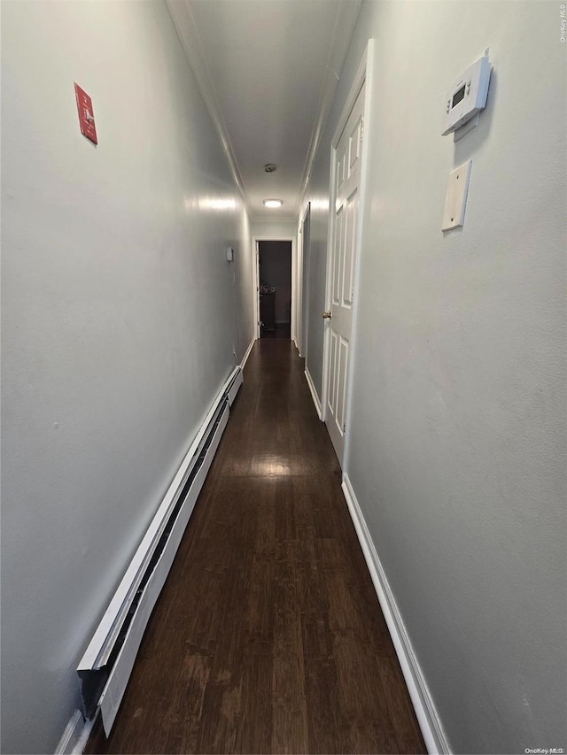 hallway featuring ornamental molding, dark hardwood / wood-style floors, and a baseboard heating unit