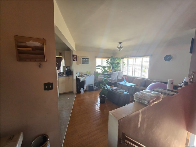 living room featuring light wood-type flooring and a wall unit AC