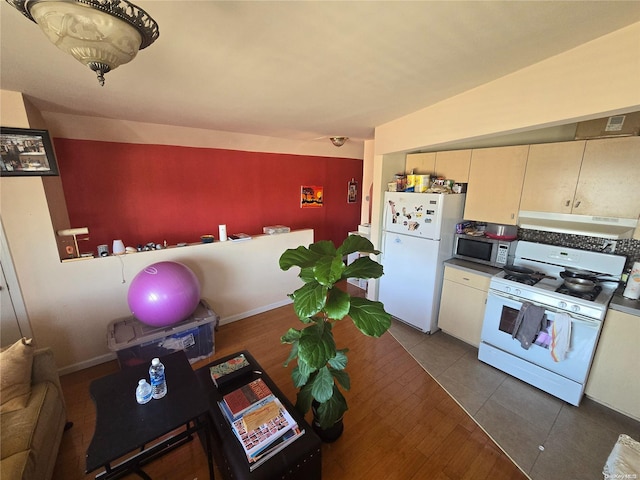 kitchen with white appliances, dark hardwood / wood-style floors, extractor fan, and lofted ceiling