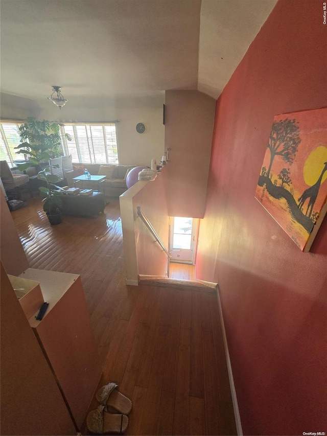 hallway featuring lofted ceiling and hardwood / wood-style flooring