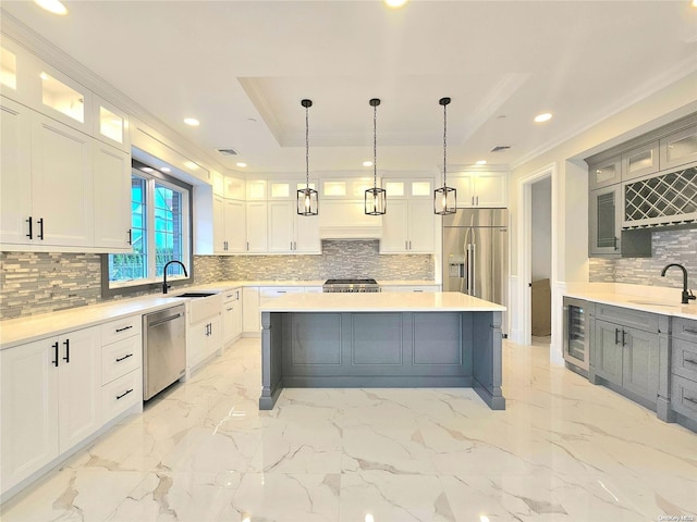 kitchen featuring beverage cooler, white cabinets, hanging light fixtures, and appliances with stainless steel finishes