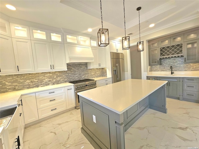 kitchen with white cabinets, premium appliances, a kitchen island, and backsplash