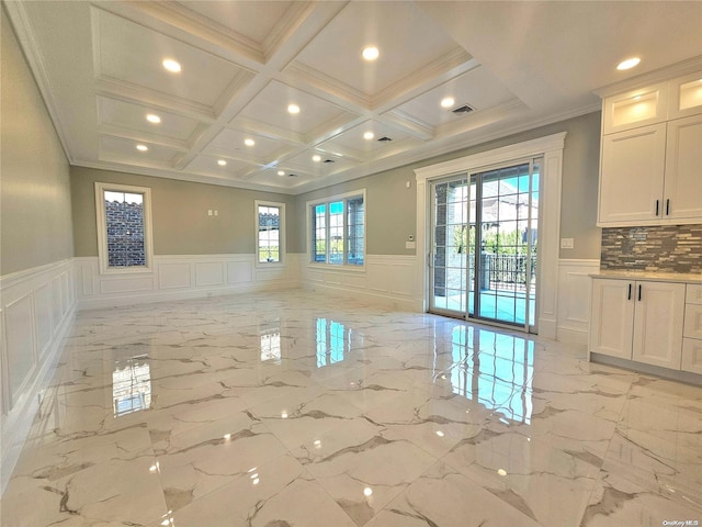 interior space with beam ceiling, a healthy amount of sunlight, coffered ceiling, and ornamental molding